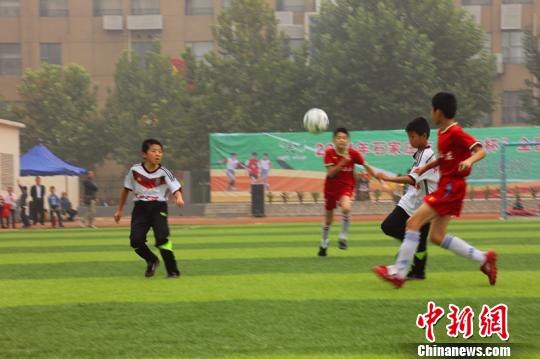 图为石家庄市谈固小学足球队和太原市双北小学足球队的孩子们在比赛中