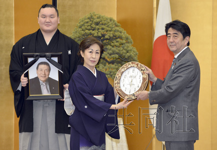 现任横纲白鹏手捧大鹏遗像出席了仪式.共同社